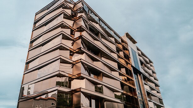 A multi-story hotel with a modern architectural design, featuring a prominent sign at the top. - Best Louis Hamilton Hotel Gijang (Busan)
