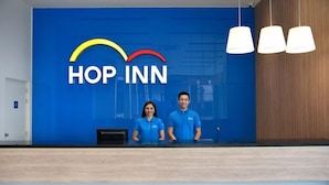 Una recepción con pared azul y el logotipo "HOP INN".