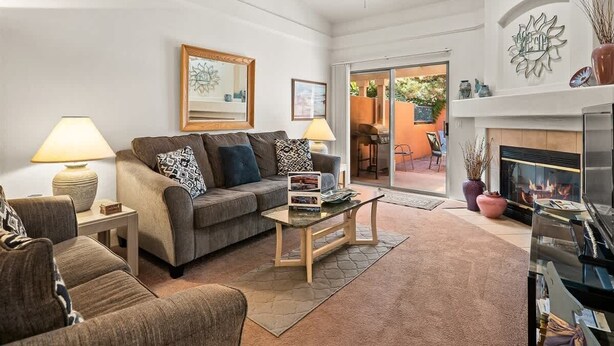 A living room with a sofa, coffee table, lamps, and a fireplace. - Light, Bright, Stylish Condo Nepenthe West Sedona (Sedona)