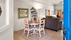 A dining area with a round table and chairs, a sofa, and a blue door. - Light, Bright, Stylish Condo Nepenthe West Sedona (Sedona)