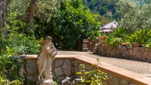 A stone pathway leading to a statue in a garden setting. - Stunning Mountain Views and Pool – Villas Ca'n Tamany & Ca'n Baixo (soller)