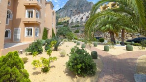 A courtyard with a palm tree, various shrubs, and a building with multiple balconies. - Residencial Jazmines by Interhome (Calpe/Calp)