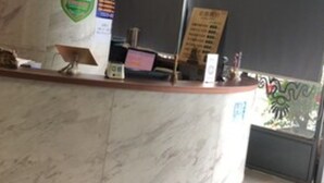 A marble reception desk with a digital screen, a bulletin board, and a sign on the wall. - Ai Luo Si (Guangzhou)