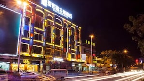 A brightly lit hotel with multiple floors and a prominent sign. - Ai Luo Si (Guangzhou)