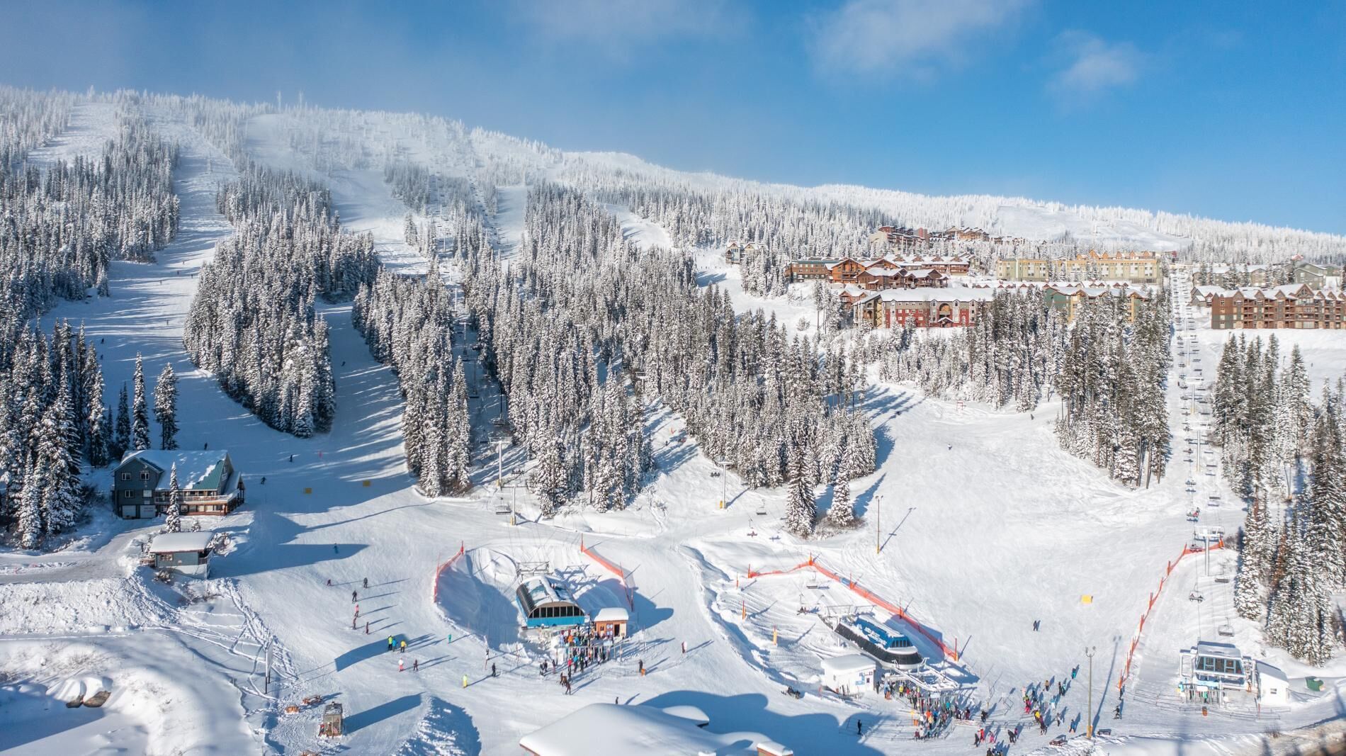 A ski resort with multiple lodges, ski lifts, and a snow-covered landscape.