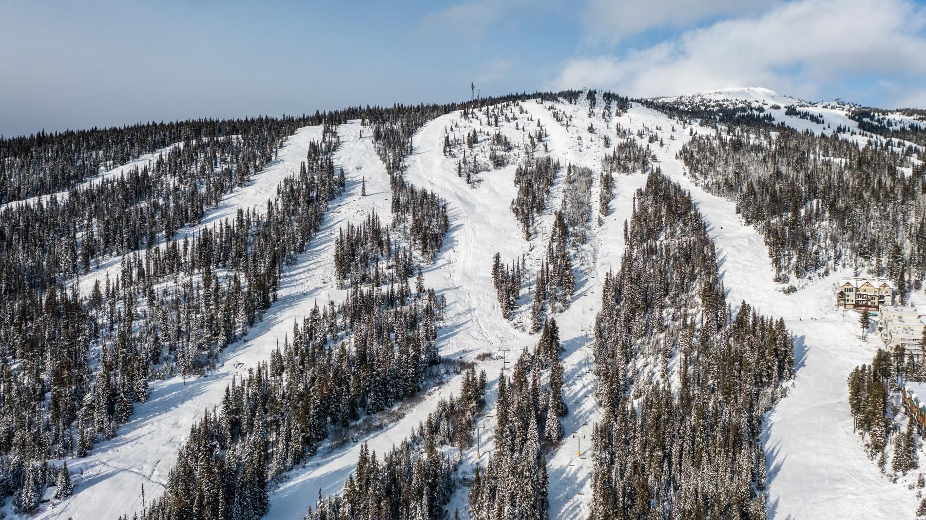 A snow-covered mountain with a ski resort, including ski trails and a lodge.