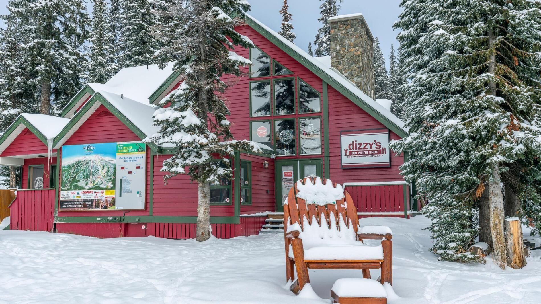 A red building with a large window and a sign for 'Dizzy's Big White Shop'.