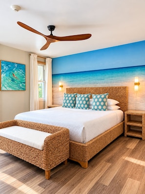 Un dormitorio con una cama grande, un ventilador de techo, un mural de playa y una ventana con cortinas.