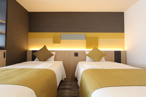 A hotel room with two beds, a wooden headboard, and a wall-mounted light fixture. - KOKO HOTEL Tsukiji Ginza (Tokyo)
