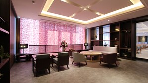 Een modern interieur met een ronde tafel, banken en een wand met een bakstenen patroon.