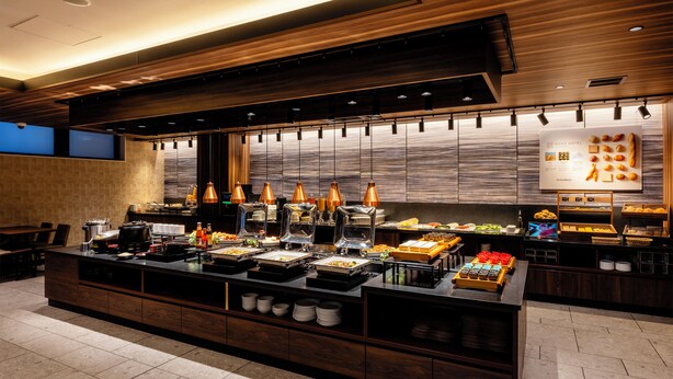 Een buffetgedeelte met diverse gerechten en een groot bord waarop het hotel wordt aangekondigd.