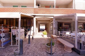 An outdoor shopping area with a variety of items on display, including textiles and furniture. - Serena 2-9: Two-room apartments in the city center, with air conditioning and a large terrace (Comacchio)