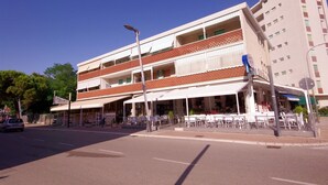 Un immeuble à plusieurs étages qui abrite un restaurant au rez-de-chaussée et dispose d’une terrasse.