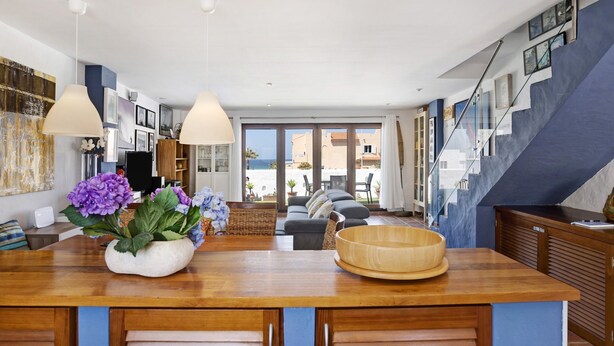 A modern living room with a wooden island, a sofa, and a dining area.