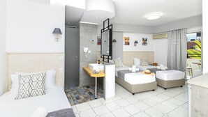 A modern hotel room with a large bed, a smaller bed, a desk with a mirror, and a bathroom with a sink and shower. - Icandy Malia (Hersonissos)