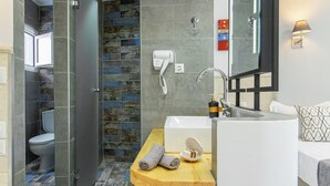 A modern bathroom with a shower, toilet, and sink. - Icandy Malia (Hersonissos)