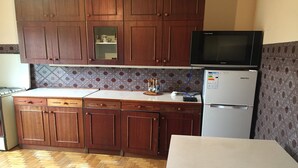 Une cuisine avec des meubles de rangement en bois, un four à micro-ondes et un réfrigérateur.