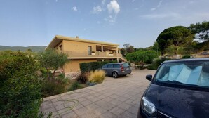 Een tweelaags huis met een balkon, een oprit en een geparkeerde auto.
