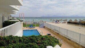 Zona de piscina con vistas a la playa y al océano.