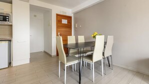 A dining area with a table and chairs, a microwave, and a door. - Esmeralda apartment in Ibiza!!! 301 (Ibiza / Eivissa)