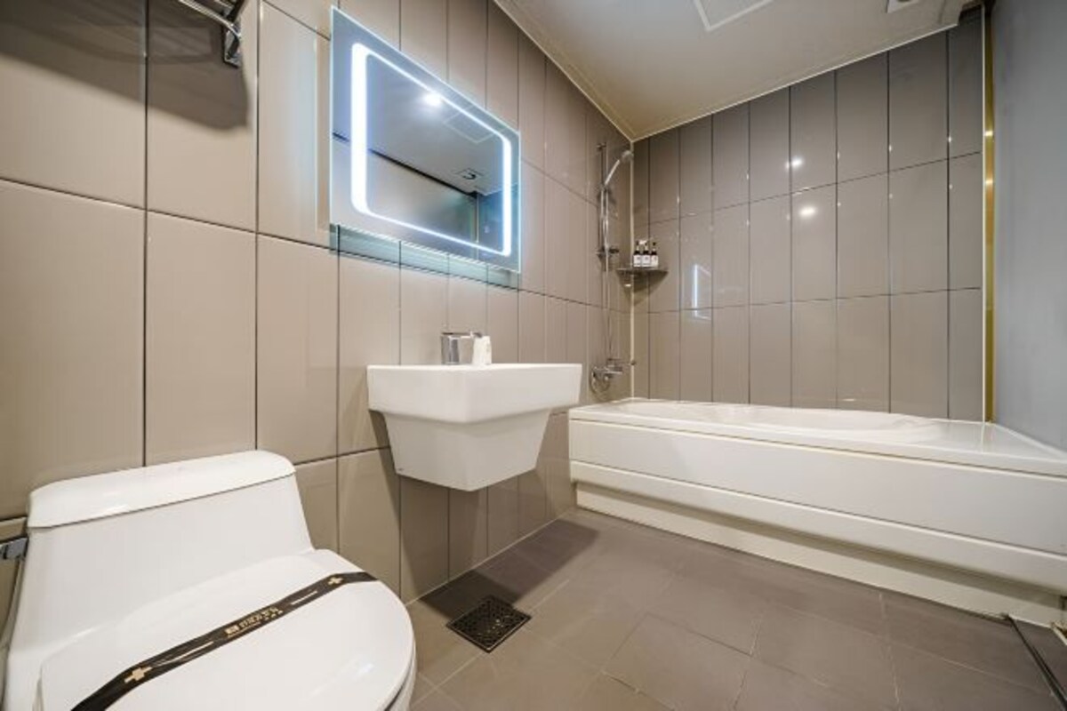 A modern bathroom with a toilet, sink, and bathtub.
