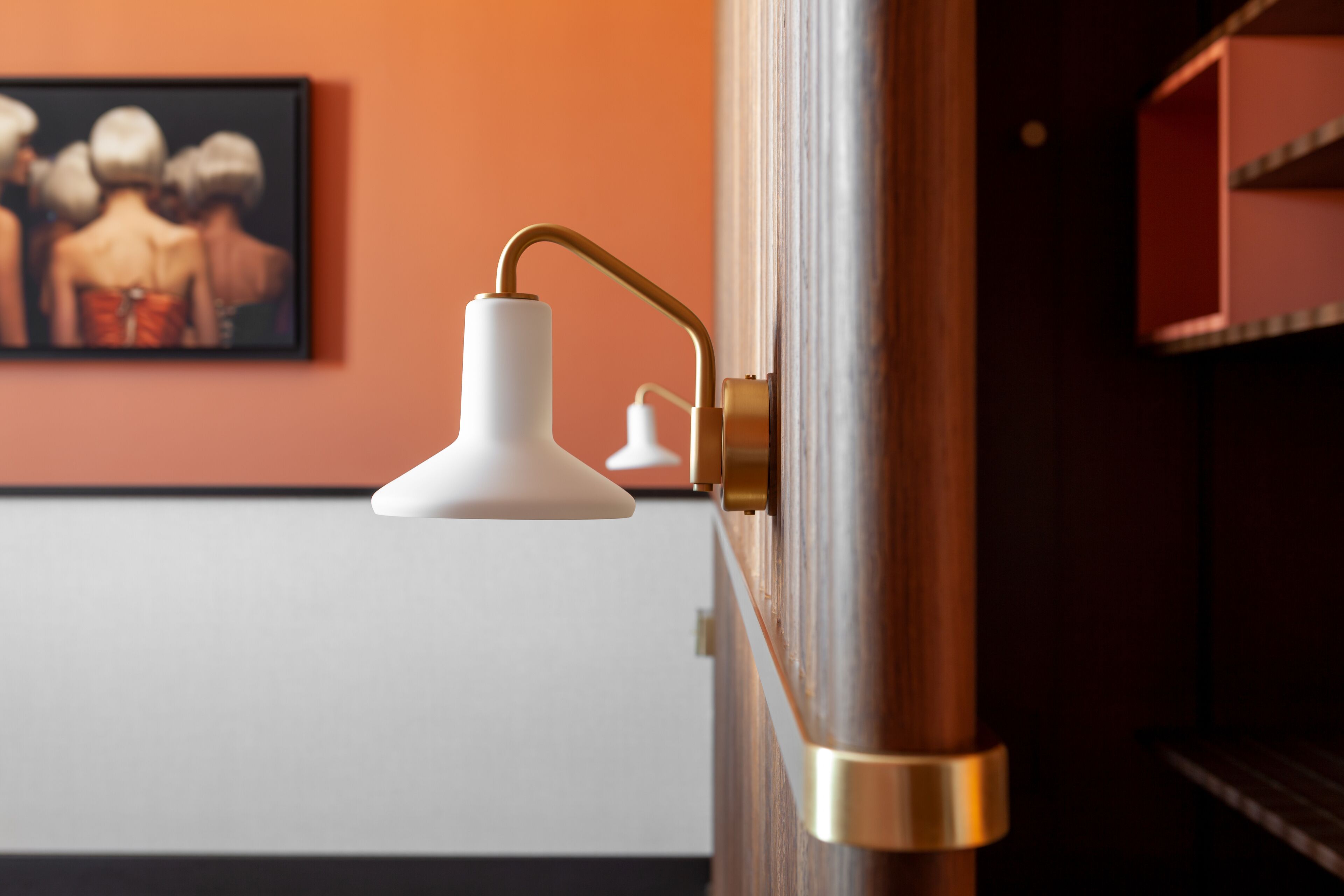 A close-up of a brass door handle with a white pendant light fixture.