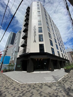 Un bâtiment moderne dont la façade est ornée d’une grande enseigne « CORDIA », avec une entrée d’angle dotée de portes vitrées et d’un auvent noir.