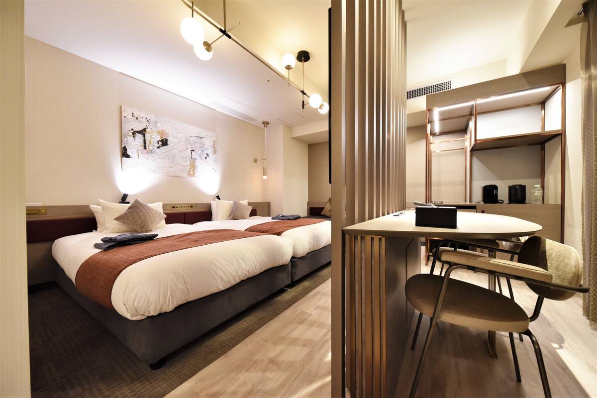 Een moderne hotelkamer met een groot bed, een eettafel en een aparte zithoek.