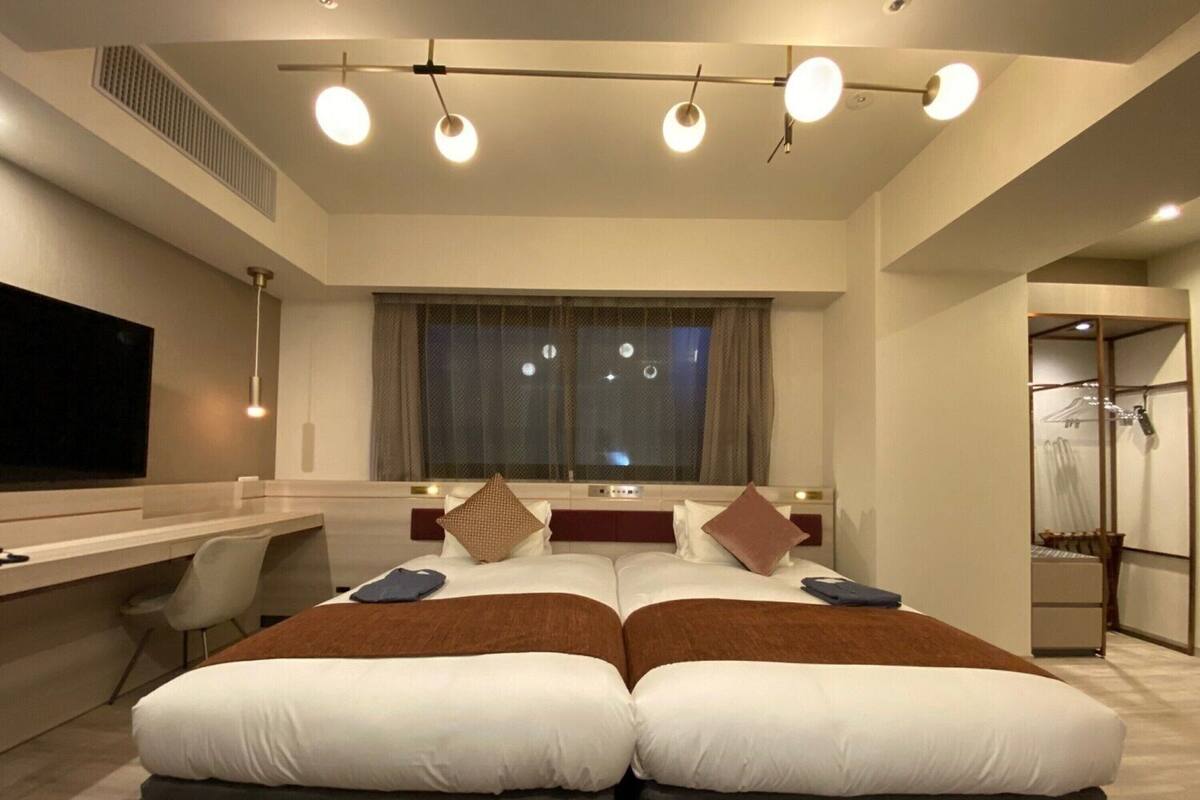 Een moderne hotelkamer met een groot bed, een bureau en een televisie.