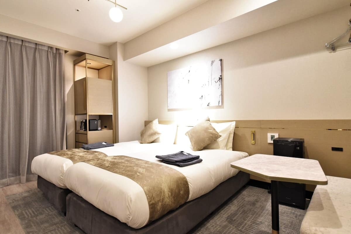 Een moderne hotelkamer met een groot bed, nachtkastjes, een bureau en een ingebouwde televisie.