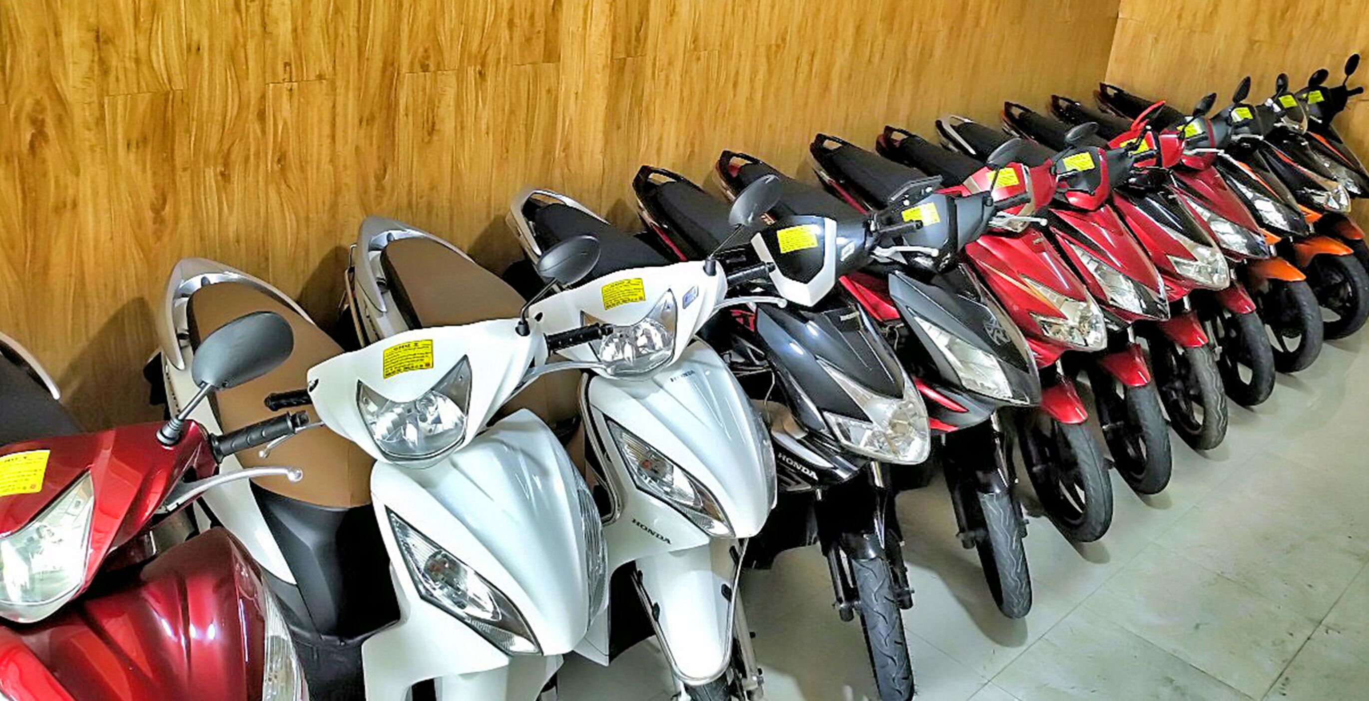 En rad uppställda motorcyklar i ett garage.