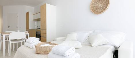 Una habitación de hotel con cama, zona de comedor y kitchenette.