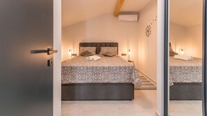 A bedroom with a bed, bedside tables, and a mirror. - Modern villa BlackWood in Crno, secluded area, near Zadar center, near the beach, private pool, en suite bathrooms (Crno)