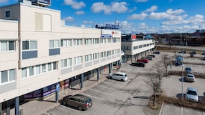A hotel with a sign reading "HOTELLI LOIMU" and a parking lot with several cars. - Hotelli Loimu (Raisio)