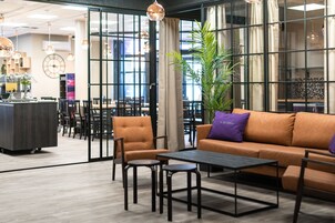 Un área de descanso moderna con un sofá, sillones y una mesita de centro.