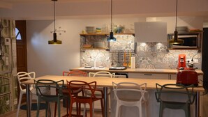 Cozinha moderna com ilha central, banquetas, luminárias pendentes e painel de fundo padronizado.