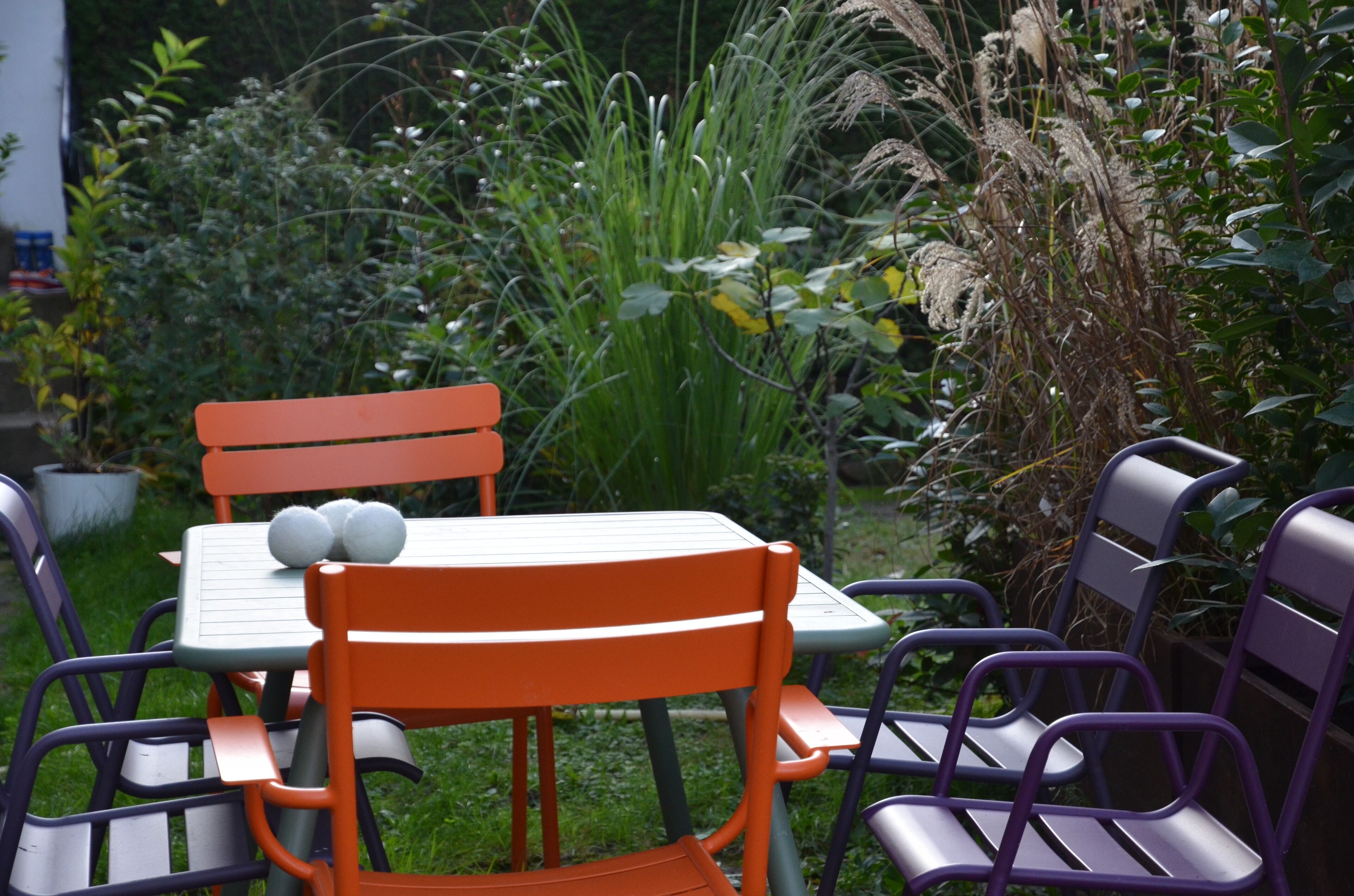Un espace extérieur aménagé avec une table et des chaises, entouré d’une végétation luxuriante.