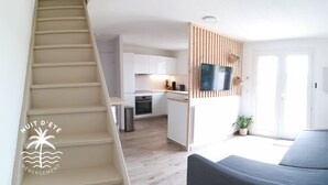 Un apartamento moderno con escalera, cocina, sala de estar y balcón.