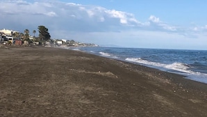 A beach with a clear sky, a sandy shore, and buildings in the background. - El Rinconcito (Rincon de la victoria)
