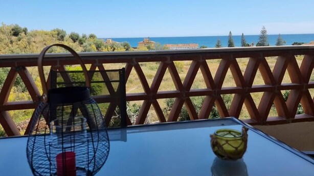 A table with a lantern and a glass bowl on a balcony overlooking a beach. - El Rinconcito (Rincon de la victoria)