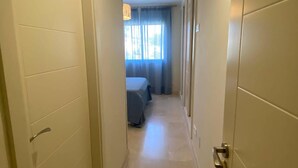 A narrow hallway with a bed and a window at the end. - El Rinconcito (Rincon de la victoria)
