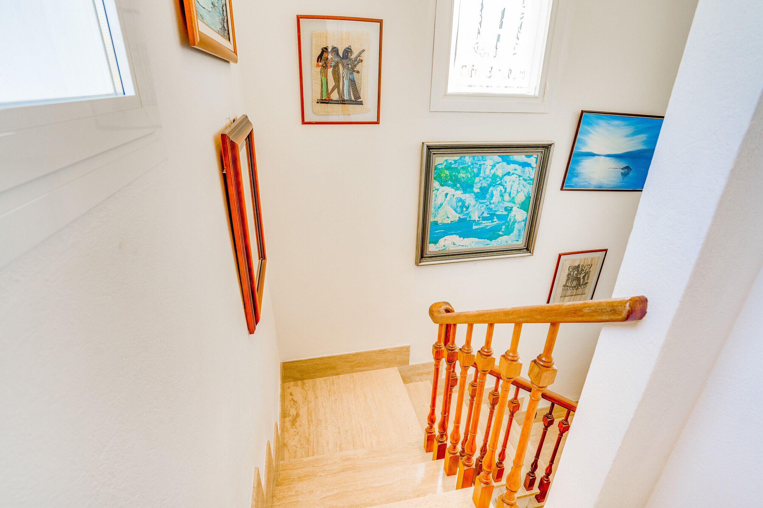 Un escalier avec des balustres en bois, une main courante et un plancher poli.