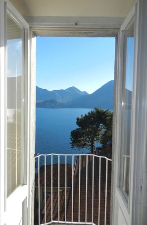 A balcony with a view of a lake and mountains.