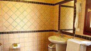 A bathroom with a toilet, sink, and mirror. - Family Rooms Budoni (Budoni)