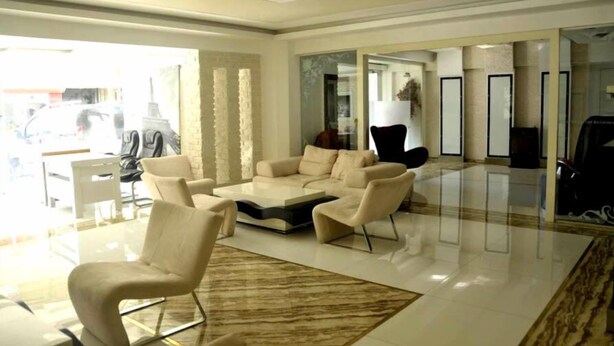 A modern living room with a sofa set, a coffee table, and a glass partition. - Mostar Hotel (Antalya)