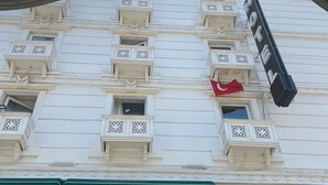 A hotel facade with multiple balconies, a prominent sign, and a green awning. - Mostar Hotel (Antalya)