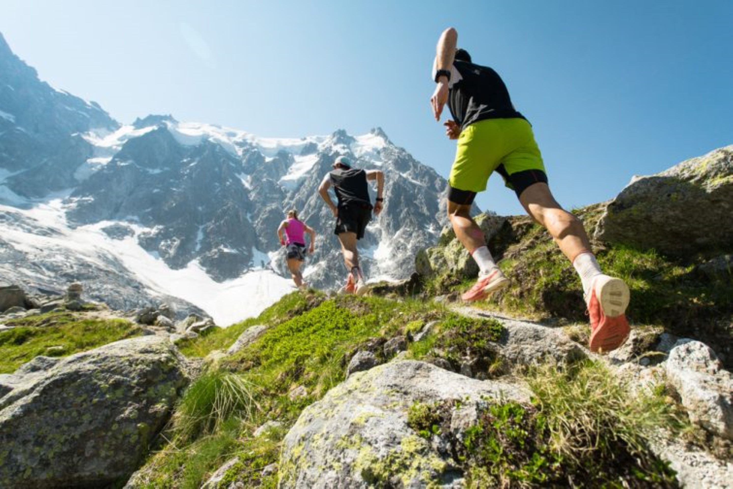 A mountainous hiking trail with rocky terrain and a clear sky.