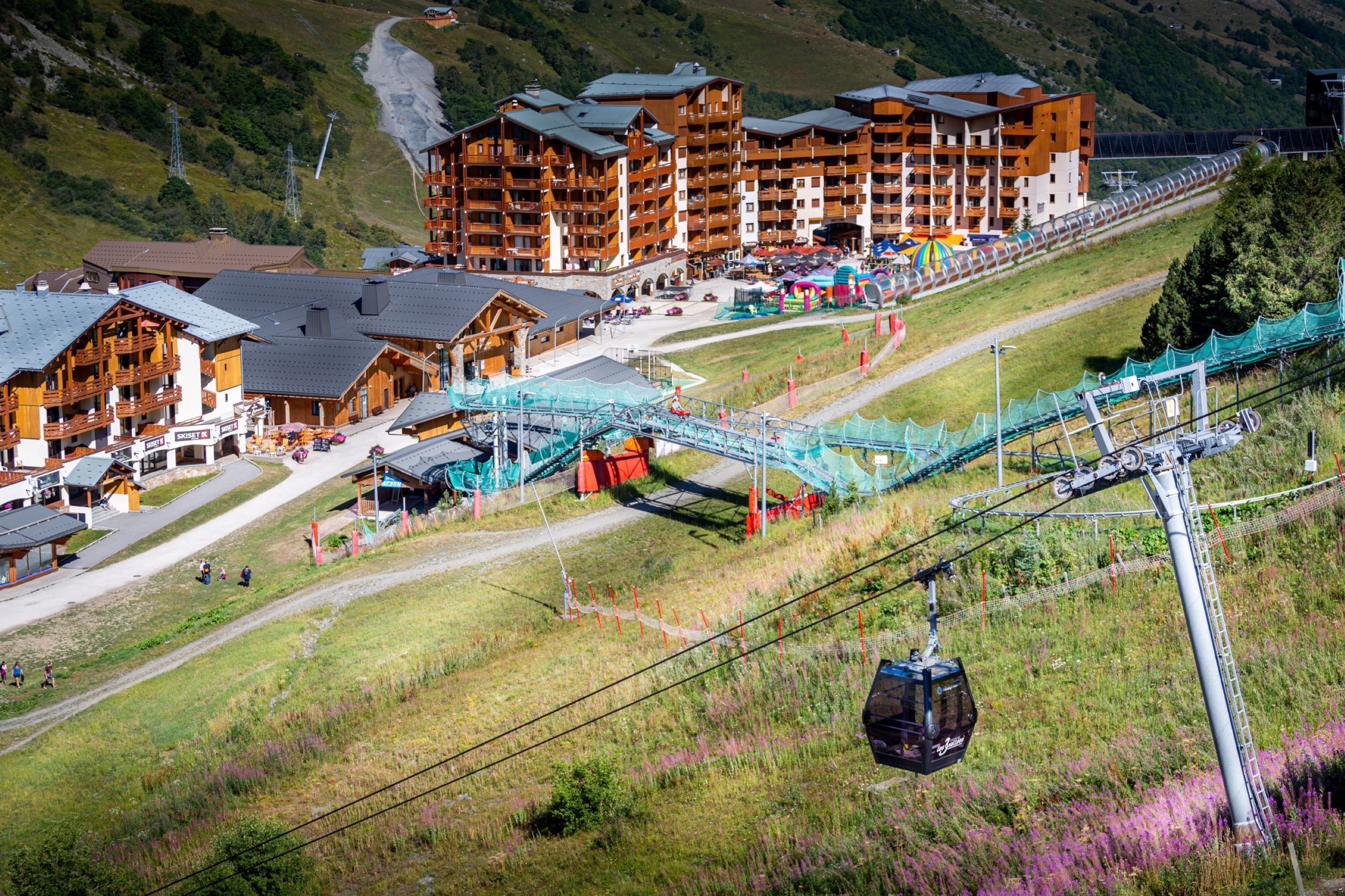 A ski resort with wooden buildings, a ski lift, and a chairlift.