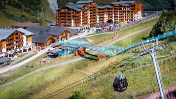 A ski resort with wooden buildings, a ski lift, and a chairlift.