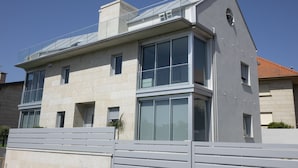 A modern two-story building with large windows and a flat roof.